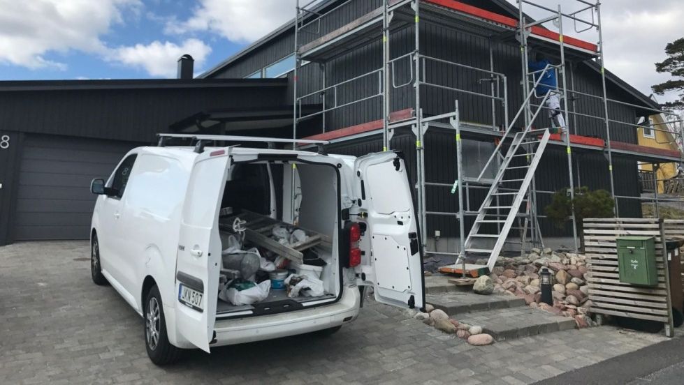 Måleriets bil står nedanför en byggställning